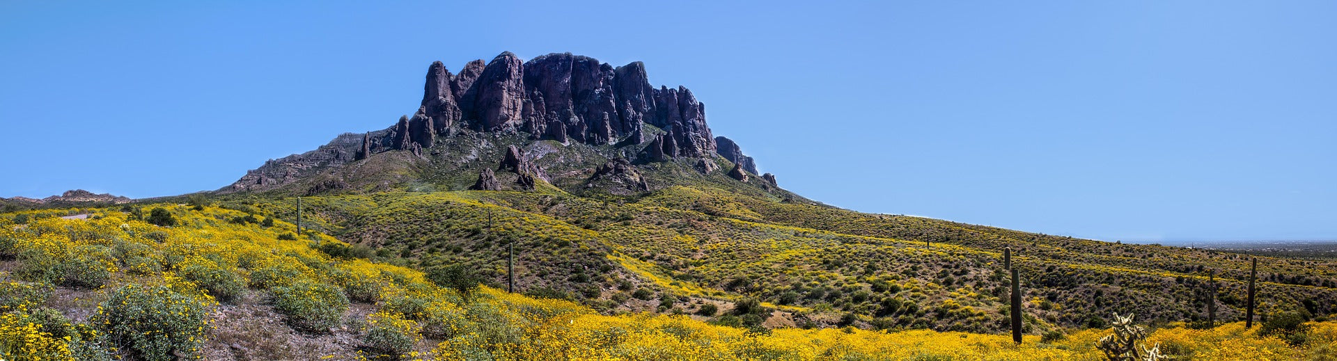 View of Superstition Mountain peak in Arizona state from hiking trails on sunny day.