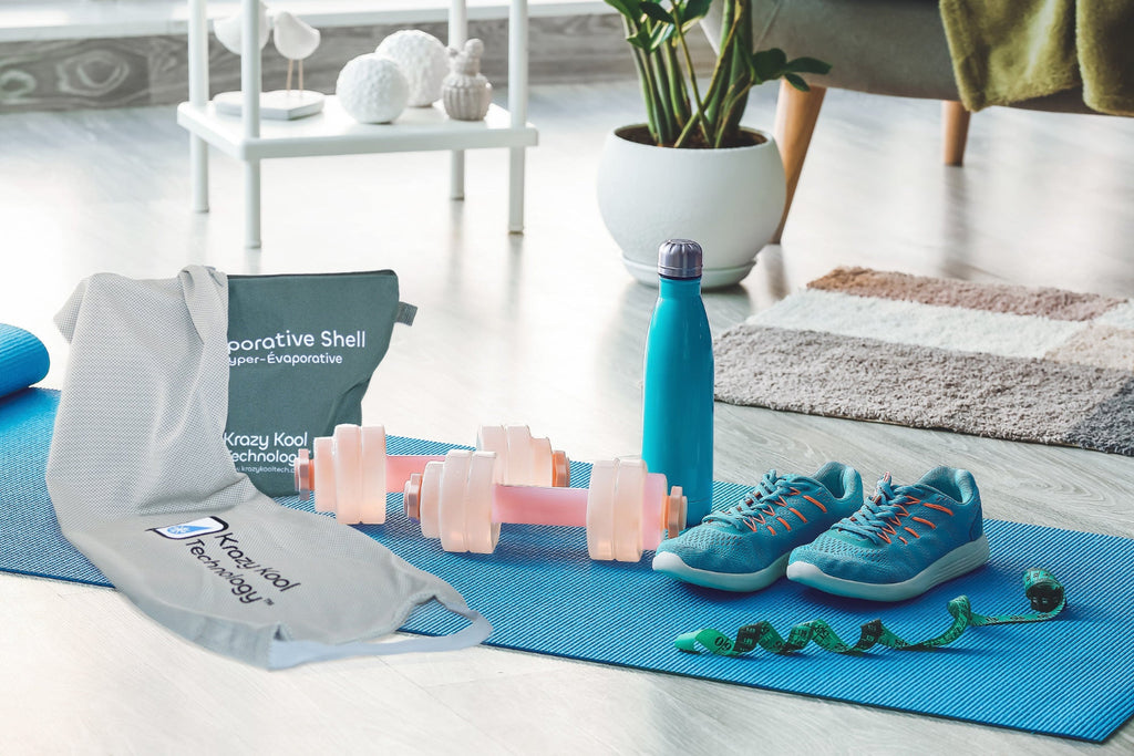 Grey cold therapy Hyper-Evaporative Shell and its Pouch resting on a blue yoga mat, alongside green running shoes, dumbbells, and a water bottle, showcasing a fitness and wellness setup for active living.