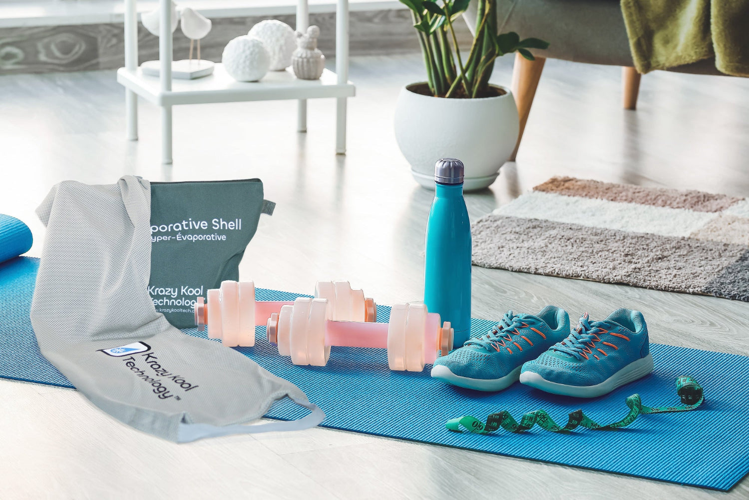 Grey cold therapy Hyper-Evaporative Shell and its Pouch resting on a blue yoga mat, alongside green running shoes, dumbbells, and a water bottle, showcasing a fitness and wellness setup for active living.
