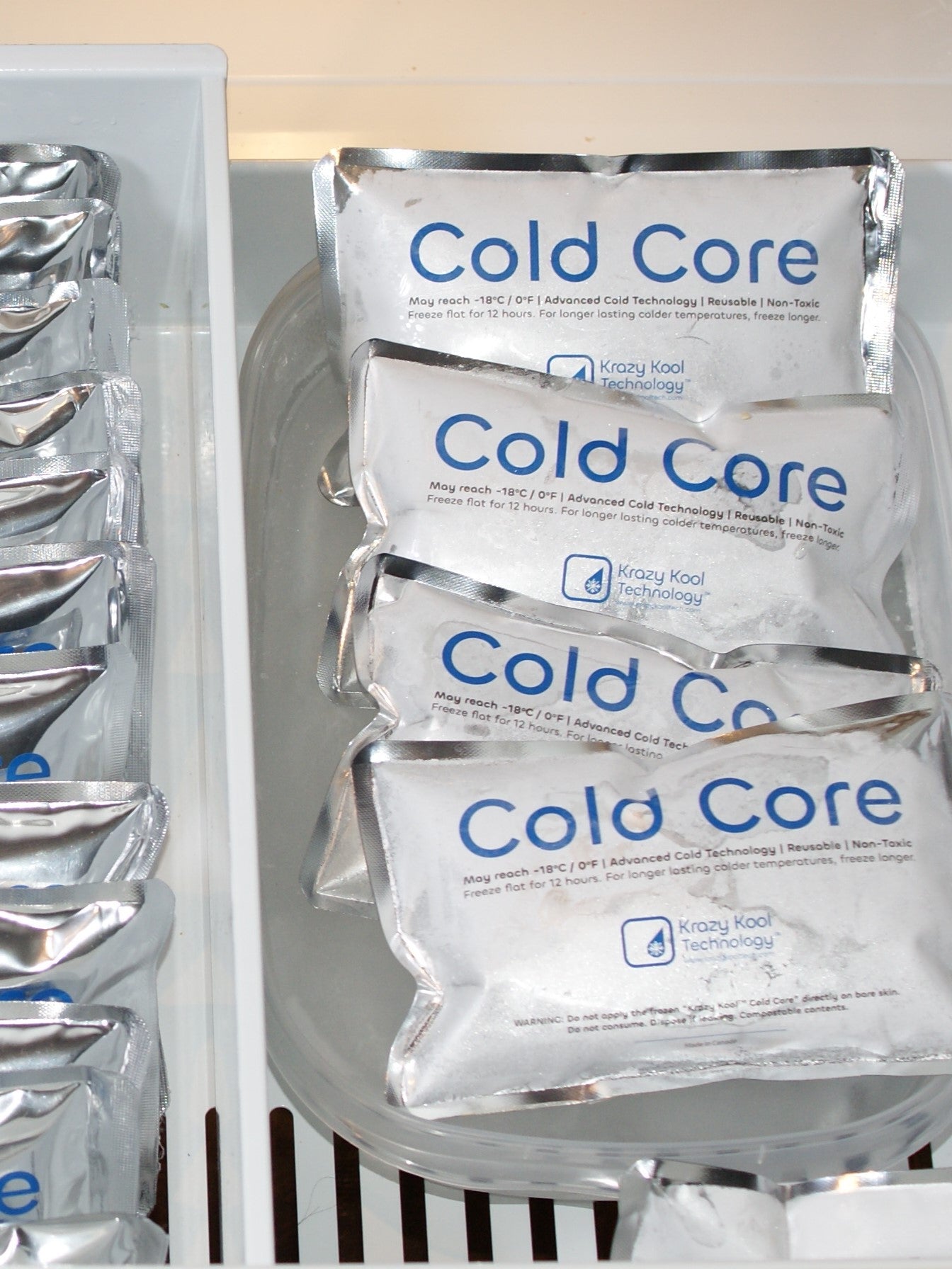 Frosted Cold Core ice packs frozen in bottom drawer refrigerator freezer next to unfrozen ones