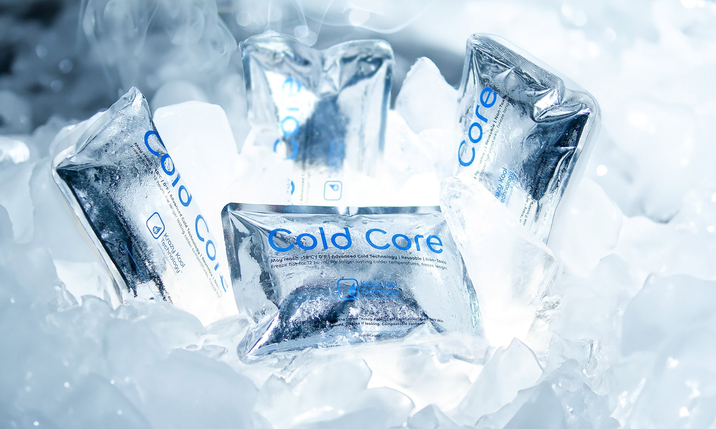 Four illuminated frozen Cold Core ice packs in chunks of ice and embedded in a block of ice with frost and smoke.