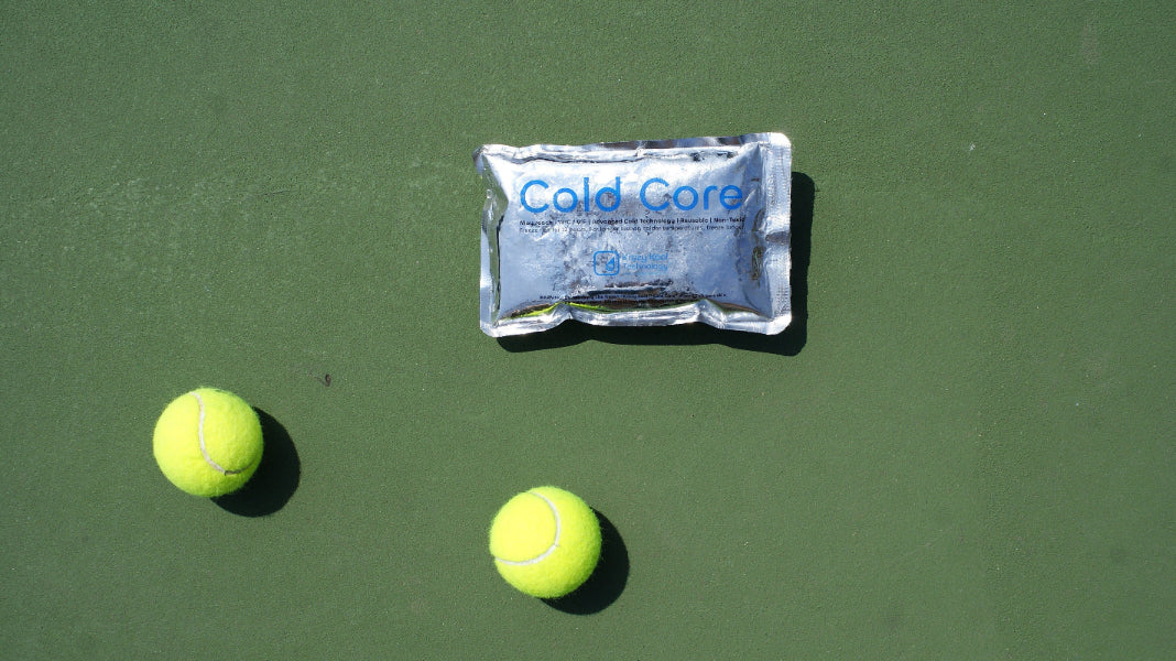 Cold Core pack and tennis balls on a green hard court