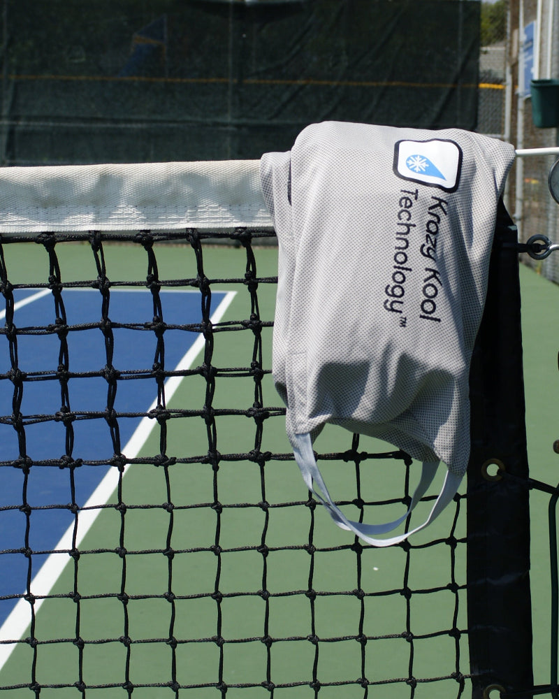 Krazy Kool Technology cooling System hanging on a tennis court net with a clear blue sky background