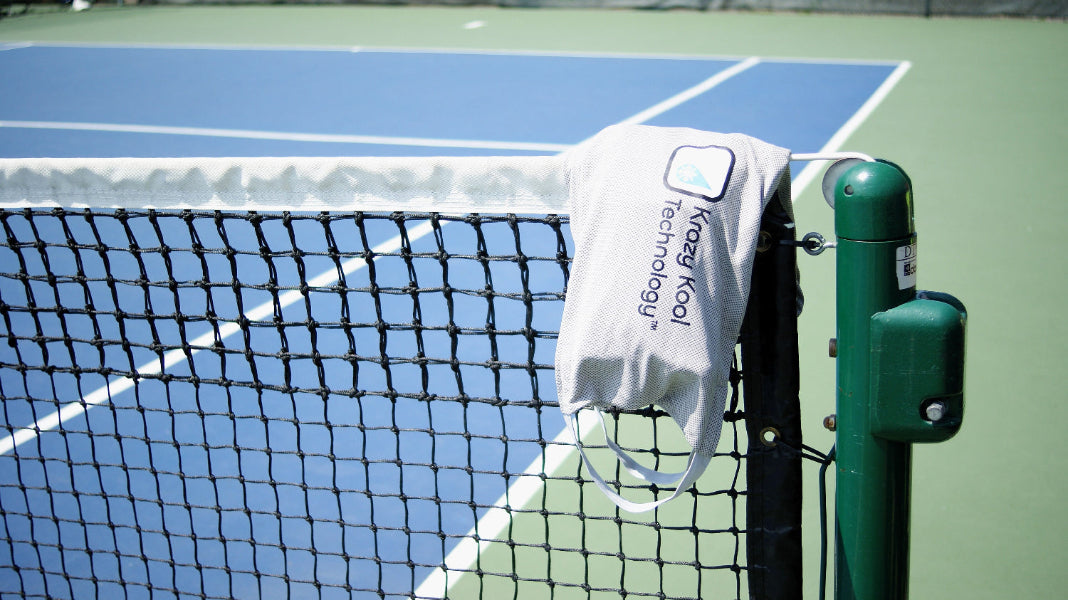 Krazy Kool Tech System draped over a tennis net on a hard court on sunny day