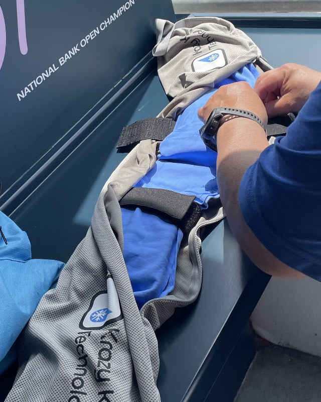 Person adjusting and assembling a Krazy Kool Tech blue and gray neck System outside